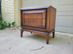 an old wooden cabinet sitting on the sidewalk