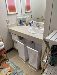 a white sink sitting next to a mirror in a bathroom on top of a counter