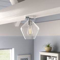 a light that is hanging from the ceiling in a room with blue walls and furniture