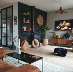 a living room filled with lots of furniture next to a wall mounted art piece on the wall