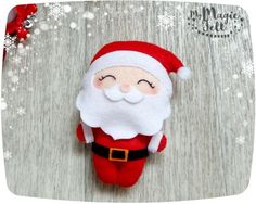 a red and white santa clause doll laying on top of a wooden floor with snow flakes