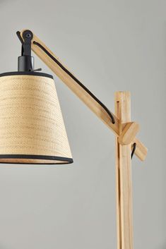 a lamp that is on top of a wooden stand with a light shade over it