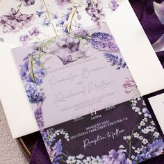 wedding stationery with purple and white flowers on it