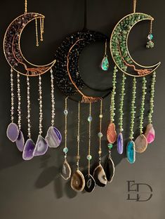 a wall hanging with several different types of jewelry on it's sides and the moon in the middle