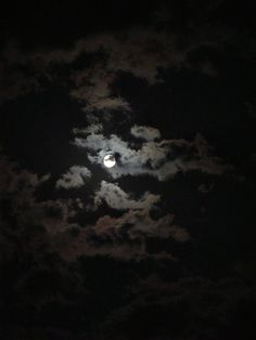 the moon is shining brightly in the dark night sky with fluffy clouds and black background