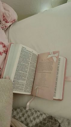 an open book sitting on top of a bed