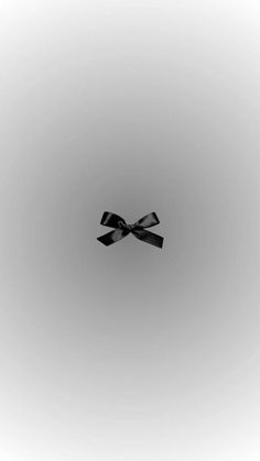 a black bow is in the middle of a gray background