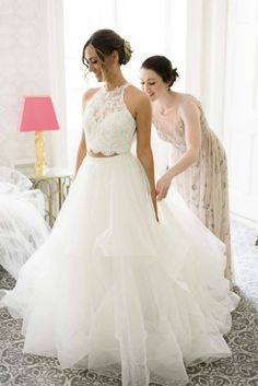 two women in wedding dresses looking at each other