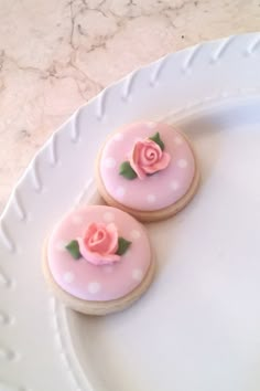 two decorated cookies sitting on top of a white plate