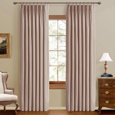 the curtains in this living room are lined with light pink drapes and pleated panels