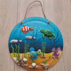 a paper plate with an ocean scene painted on it and sea animals in the background