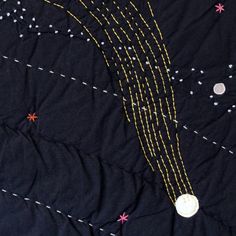 a black quilt with yellow and pink stars on it