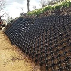 there is a large pile of plastic bottles on the side of the road with a tractor in the background