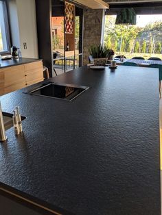 a large kitchen island with black granite countertops and stainless steel faucet handles