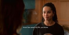 a woman with dreadlocks standing in front of a kitchen counter talking to another woman