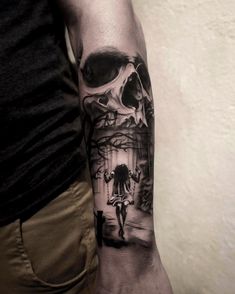 a man's arm with a black and white tattoo on it, featuring a skull