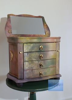 an old dresser with a mirror on it's top and some metal knobs