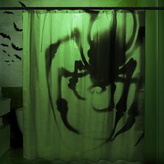 the shadow of a spider on a shower curtain in a bathroom with bats flying around