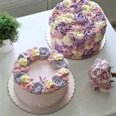 there are two cakes on the table with pink and purple frosting, one is decorated with flowers