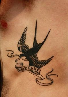 a man's chest with a bird and scroll tattoo on it, which reads hold fast