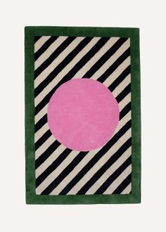 a black and white striped rug with a pink circle on the center in front of a green border