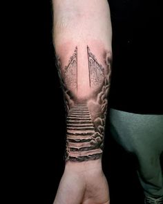 a person with a tattoo on their arm is holding up a stairway to the sky