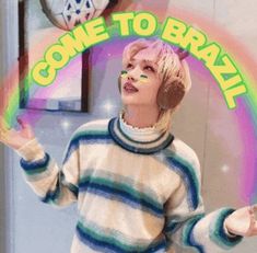 a woman with pink hair and headphones standing in front of a sign that says, come to brazil