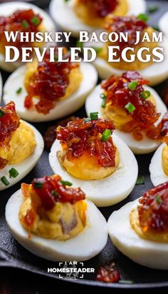 deviled eggs with bacon jam and green onions on a black plate text reads, whiskey bacon jam deviled eggs