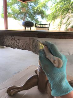 a person wearing blue gloves is cleaning a wooden table with a rag on it's head