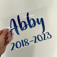 a hand holding a sign that says abby 2013 - 2013 on it with blue ink