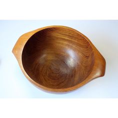 a wooden bowl sitting on top of a white table