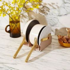 three plates and two bowls on a marble counter top with yellow flowers in the background