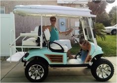 a woman sitting in a golf cart on the sidewalk