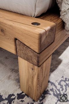 a wooden bench sitting on top of a carpeted floor next to a white pillow