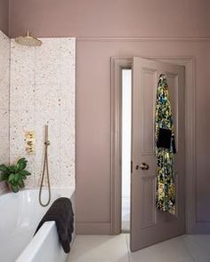 a bath room with a tub a sink and a mirror on the wall next to a door