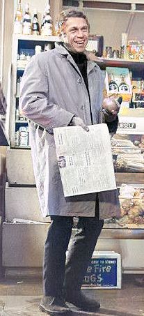 a man holding a newspaper in front of a store