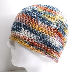 a white mannequin head wearing a multicolored knitted beanie hat