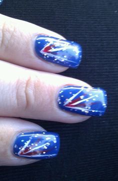 a woman's hand with red, white and blue manicures on it