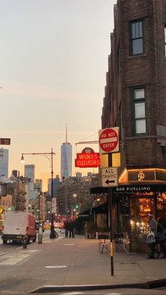 a city street filled with lots of traffic and people walking on the sidewalk next to tall buildings