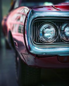 the front end of a red car with its lights on