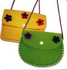 two small purses hanging from strings on a white background, one is green and the other is yellow