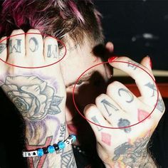 a man with tattoos holding his hands to his face