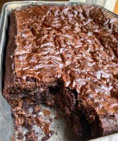 a chocolate cake that has been cut in half and is sitting on a pan with one slice missing