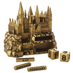 a set of gold colored dices next to a golden castle with numbers on it