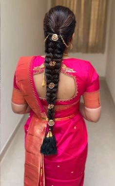 a woman in a pink sari with braids on her head