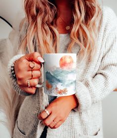 a woman holding a coffee mug in her hands