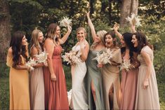 a group of women standing next to each other holding bouquets in front of them