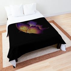 a bed with a black comforter on top of it