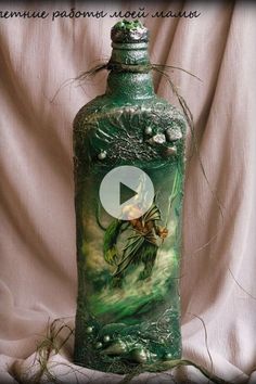 a green bottle with an image of a fairy on the side and some plants in it