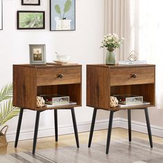 two wooden nightstands side by side with pictures on the wall and plants in vase